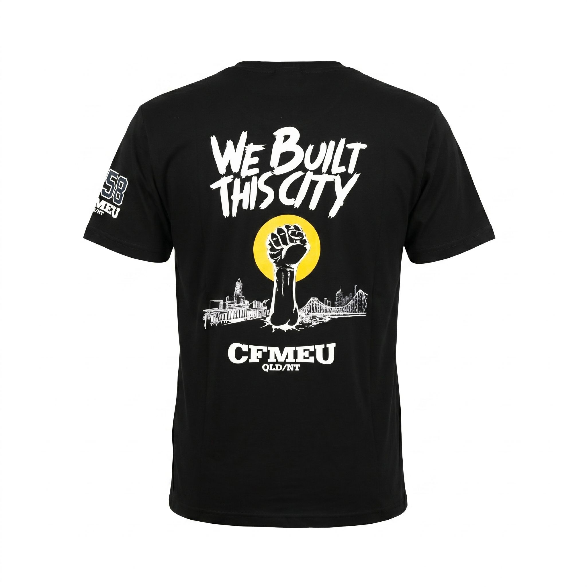 Back of black T-shirt with bold white text 'WE BUILT THIS CITY' over a yellow circle and a city skyline with a raised fist graphic beneath it—informative graphic.